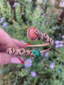 Miedziana bransoletka otwarta Szlachetna Kuźnia z dwoma okrągłymi kamieniami naturalnymi to jest ceglasty jaspis czerwony oraz intensywnie zielony jadeit oprawione techniką wire wrapping.